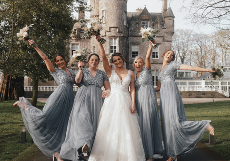 Bridal party with bouquets in air