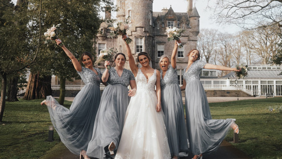 Bridal party with bouquets in air