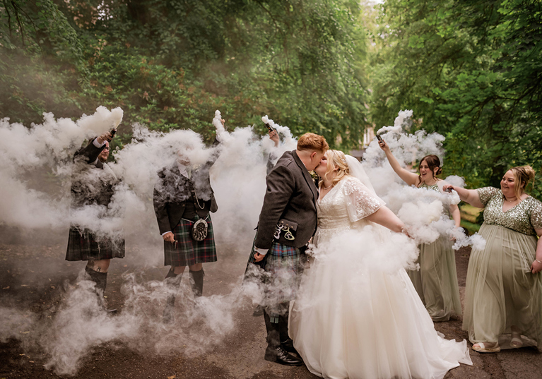 Smoke bombs go off as bride and groom share kiss in woodlands