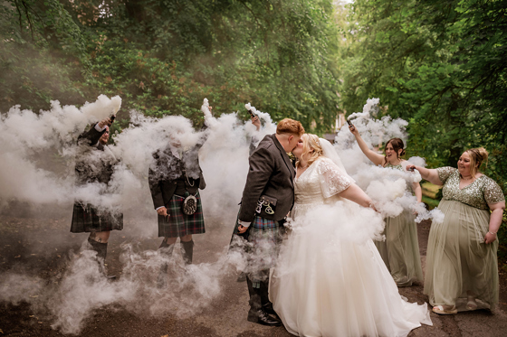Smoke bombs go off as bride and groom share kiss in woodlands