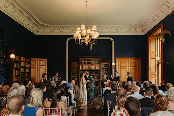 Bride and groom seal the deal with a kiss at the altar in front of clapping guests