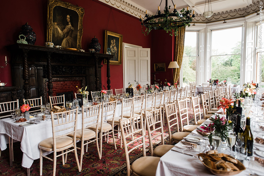 Long tables decorated with orange flowers for wedding meal 