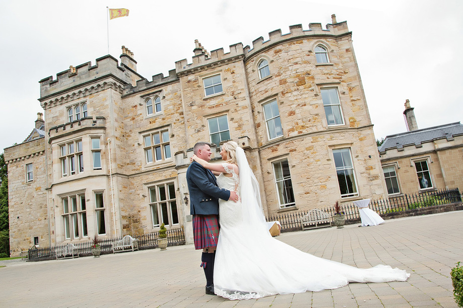 Bride and groom looking at each other outside Crossbasket Castle