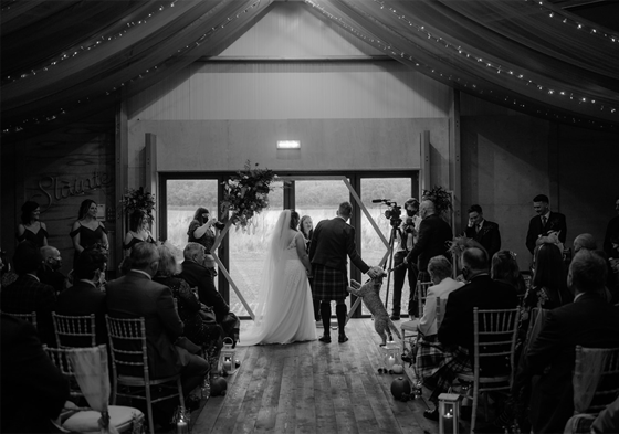 Black and white image of bride and groom at the altar