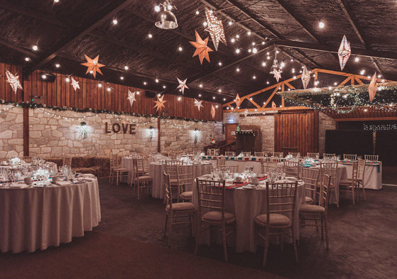 Inside barn tables decorated for a wedding with fairy lights and stars