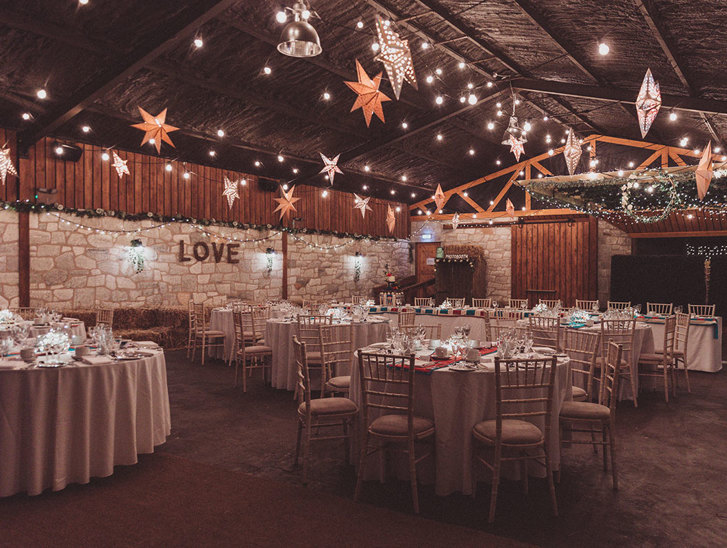 Inside barn tables decorated for a wedding with fairy lights and stars