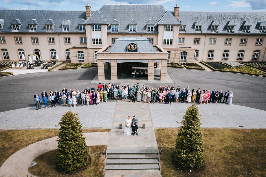 Bride and groom stand in front of their guests outside Fairmont entrance