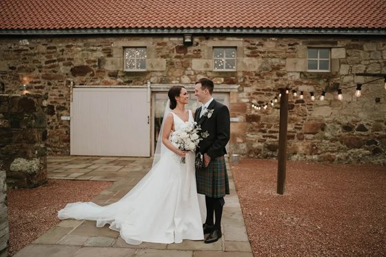 Bride and groom looking at each other outside venue