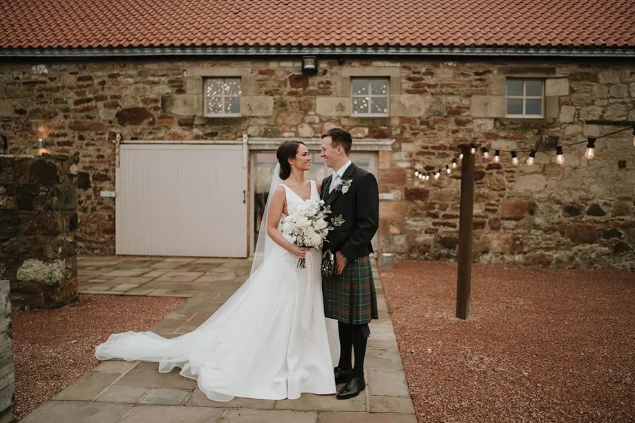 Bride and groom looking at each other outside venue