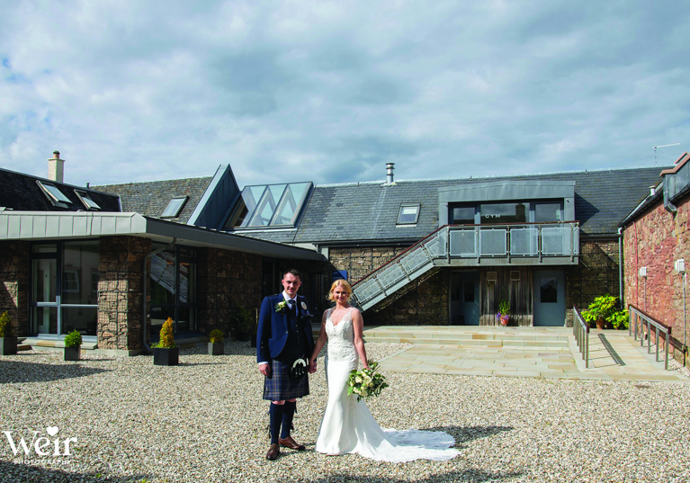 Bride and groom stand outside Ardoch Loch Lomond by Weir Photography