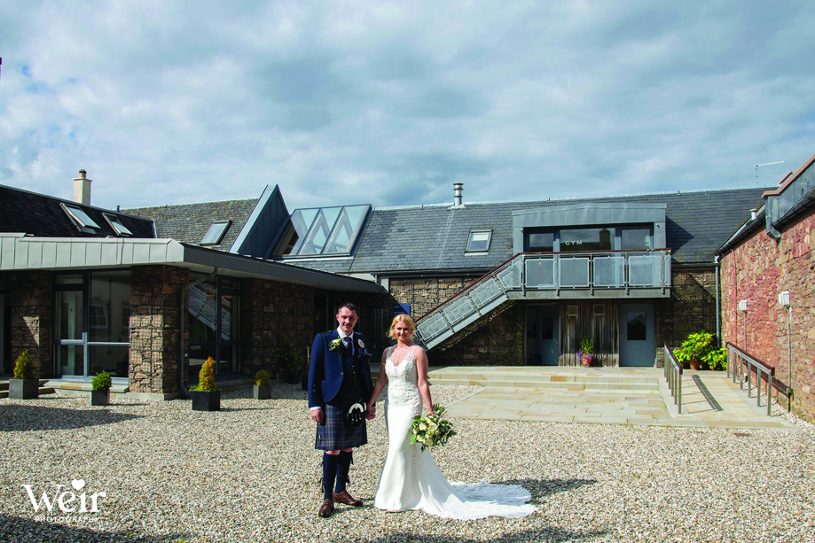 Bride and groom stand outside Ardoch Loch Lomond by Weir Photography