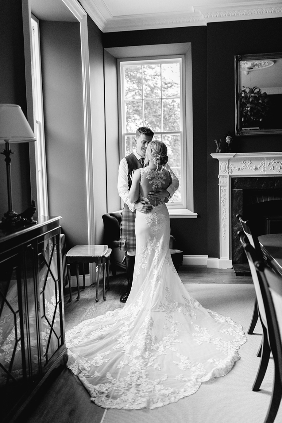 Black and white image of bride and groom embrace in wedding venue, House of Elrick in Aberdeen.