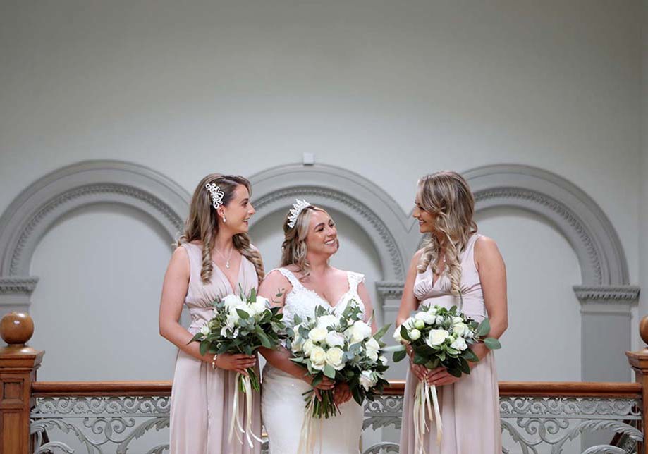 Bride smiles beside her two bridesmaids