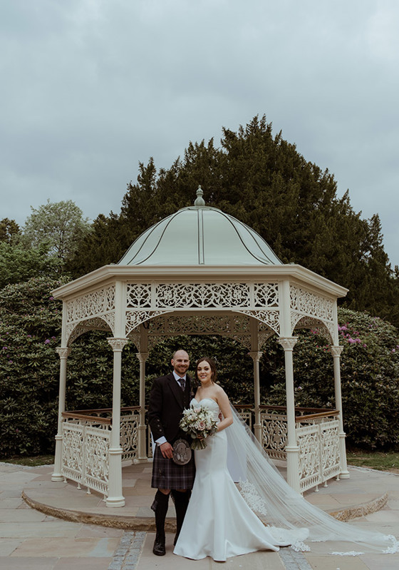 Bride and groom pose in front of Garden Pavilion