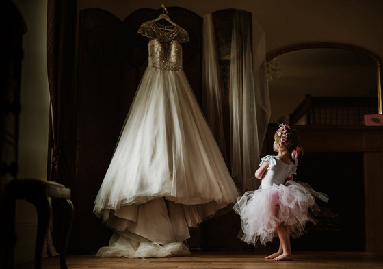 Little girl in tutu looking at wedding dress hanging up in Aberdeen Wedding Venue Logie Country House