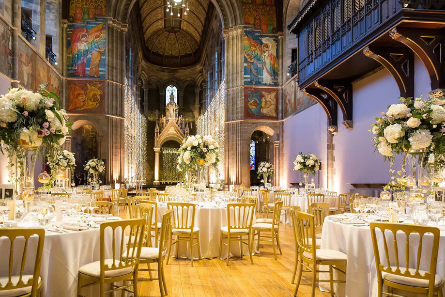 Gold chairs and white decor with large pink and white bouquets in middle of tables