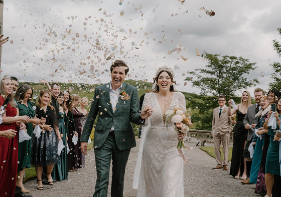 Bride and groom walk through confetti after ceremony