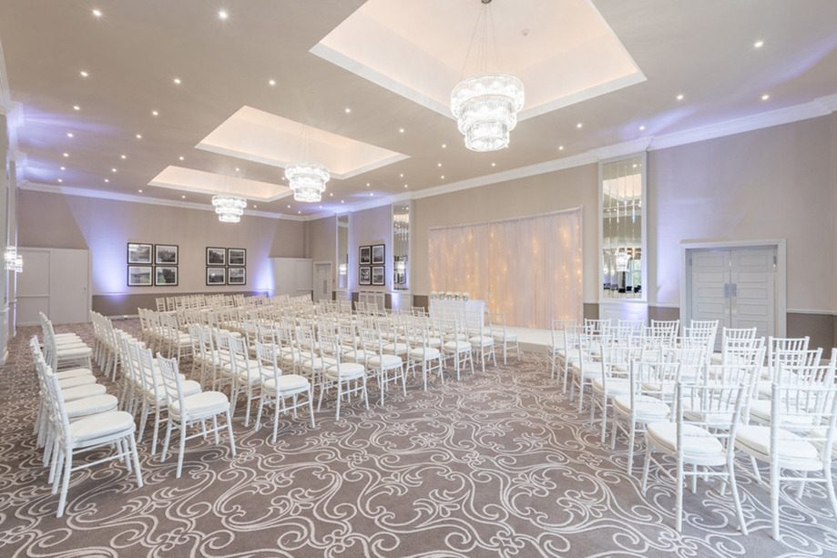 Ceremony room with white colour scheme and chandeliers