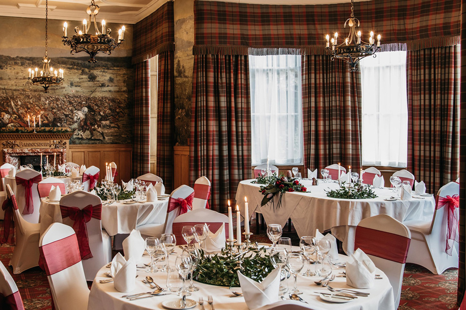 Bannockburn Suite set up for wedding meal with red accents and tartan