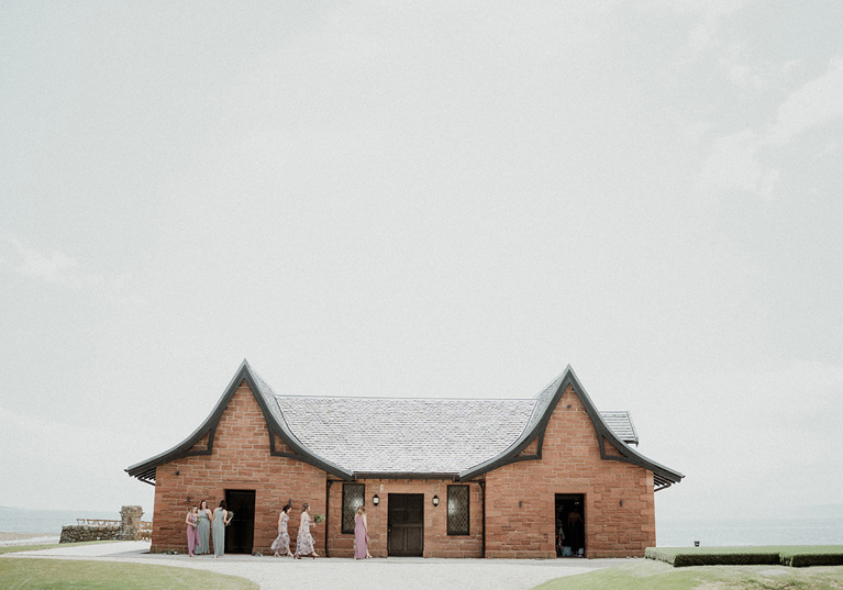 View of the boathouse with bridesmaids walking outside