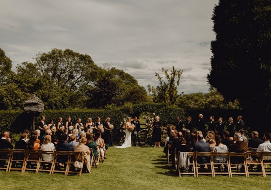 Outdoor ceremony with bride, groom and guests