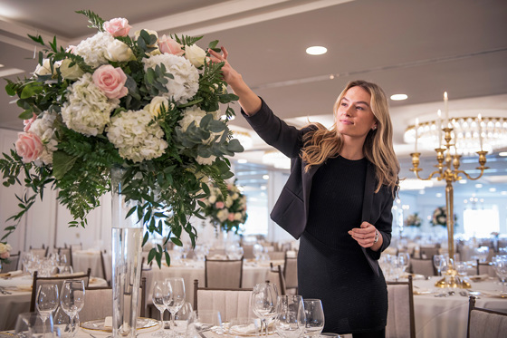 Staff member touching flowers to perfect the details 